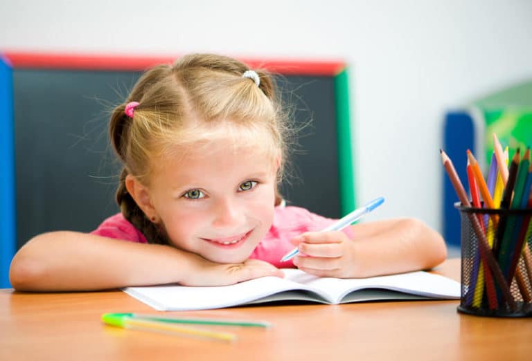 Bild zeigt fröhliches Mädchen mit einem Stift in der Hand